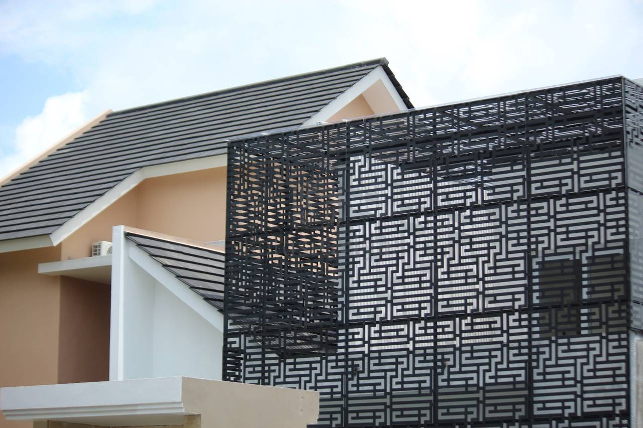 Fasad rumah tinggal dengan panel logam perforated motif geometris, aplikasi halftone pattern pada bangunan residential