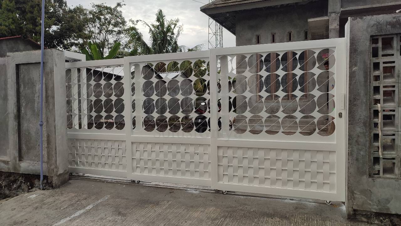 Pintu telescopic dengan panel bertumpuk rapi di sisi gudang